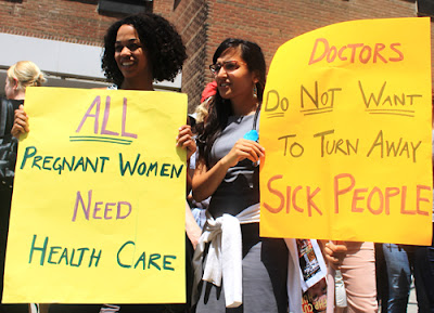 Faced with protests like this, Jason Kenney decided to thank himself for cuts to refugee health care. (Photo: Jesse McLaren)