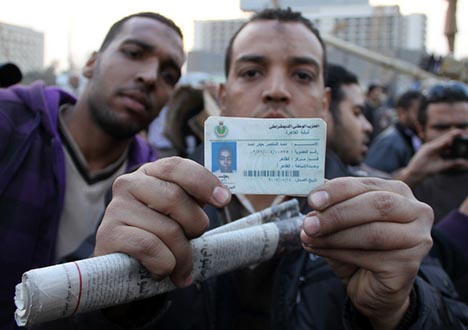 Protesters in Tahrir Square, Cairo, with identification taken from a pro-Mubarak rioter which shows that person to be a member of security forces. Feb. 2, 2011. Photo: omarroberthamilton/Flickr
