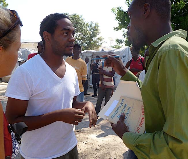 Haiti constitution in hand, a member of BAI legal team speaks to a purported landowner threatening evictions