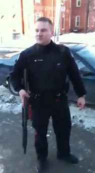 Image from a video shot by Will Dean, of a police officer attempting to gain entrance to the North American Anarchist Studies Network Conference in Toronto on Jan. 15, carrying a shotgun. He and another officer were denied entry by attendees.
