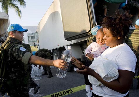 Brazilian peacekeepers from the United Nations Stabilization Mission in Haiti (MINUSTAH) distribute water and food in Port-au-Prince, Haiti. 22/Jan/2010. Port-au-Prince, Haiti. UN Photo/Marco Dormino/Flickr