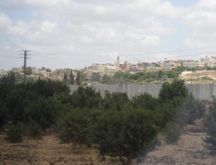 A first glimpse of the separation wall. 'You can tell from the water tanks on the roofs that these are Arab villages,' says our guide. She doesn’t mention that Palestinians need them for when Israel cuts off the water supply. Photo: Rachel Marcuse