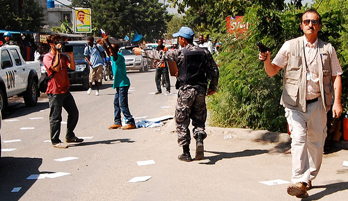 A UN police officer points a pistol at freelance journalist Ansel Hertz during the protest in Port-au-Prince, Haiti, on Oct. 15.. Photo: Gaetantguevara/Flickr