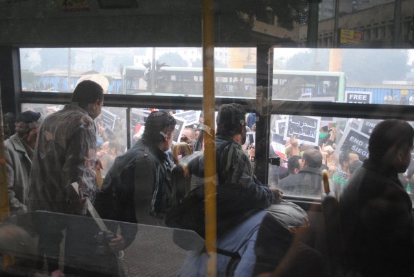 Egyptians watch GFM protests from a passing bus (photo by Brandon Delyzer bdelyzer@uvic.ca)