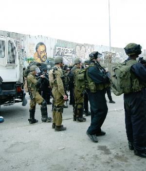 Soldiers prepare to fire at protesters. Behind them the 'skunk truck', which propels sewage-like liquid, is parked. Photo: Rana Hamadeh