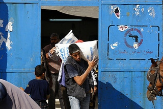 A worker carries a bag of flour at a United Nations food distribution centre.