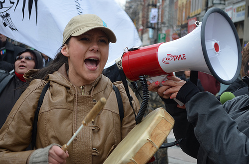 Protester with a megaphone playing the drums