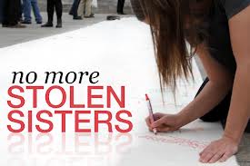 Woman signs petition on No More Stolen Sisters poster