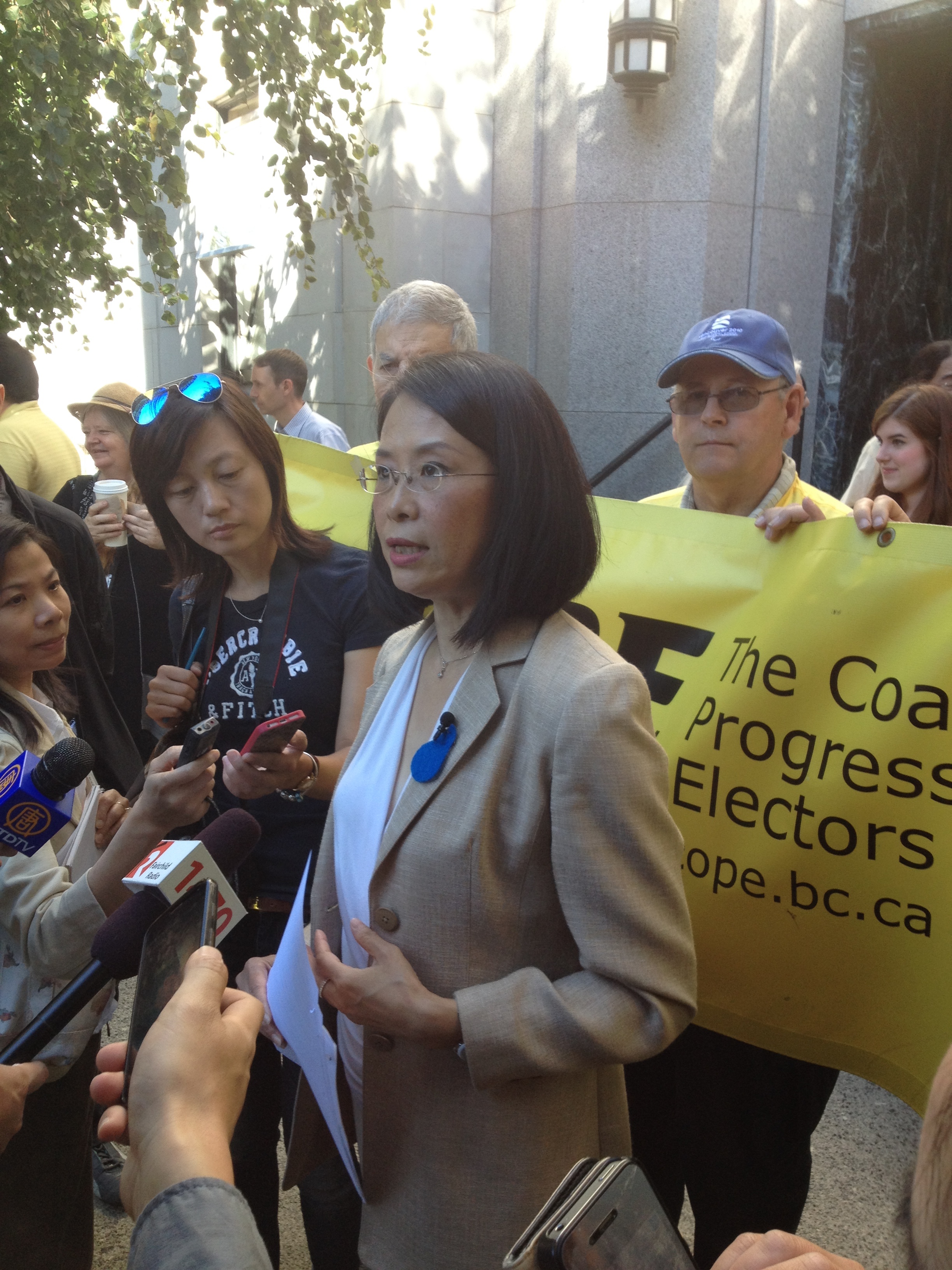 Meena Wong talks with reporters on the steps of City Hall