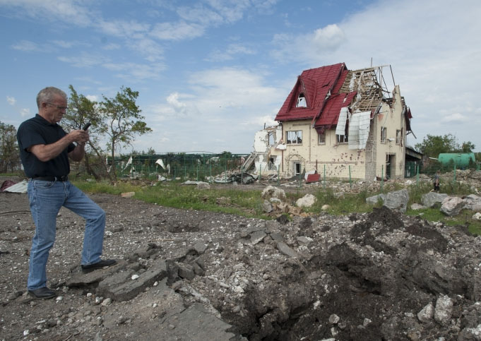 a_monitor_of_the_osce_mission_in_ukraine_examines_the_aftermath_of_shelling_in_july_2014_photo_by_osce