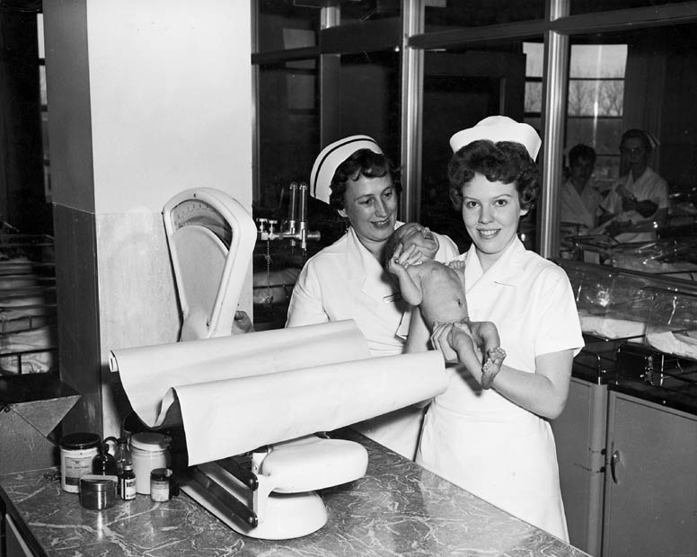 Two nurses with a baby in the nursery at Toronto East General and Orthopaedic Ho