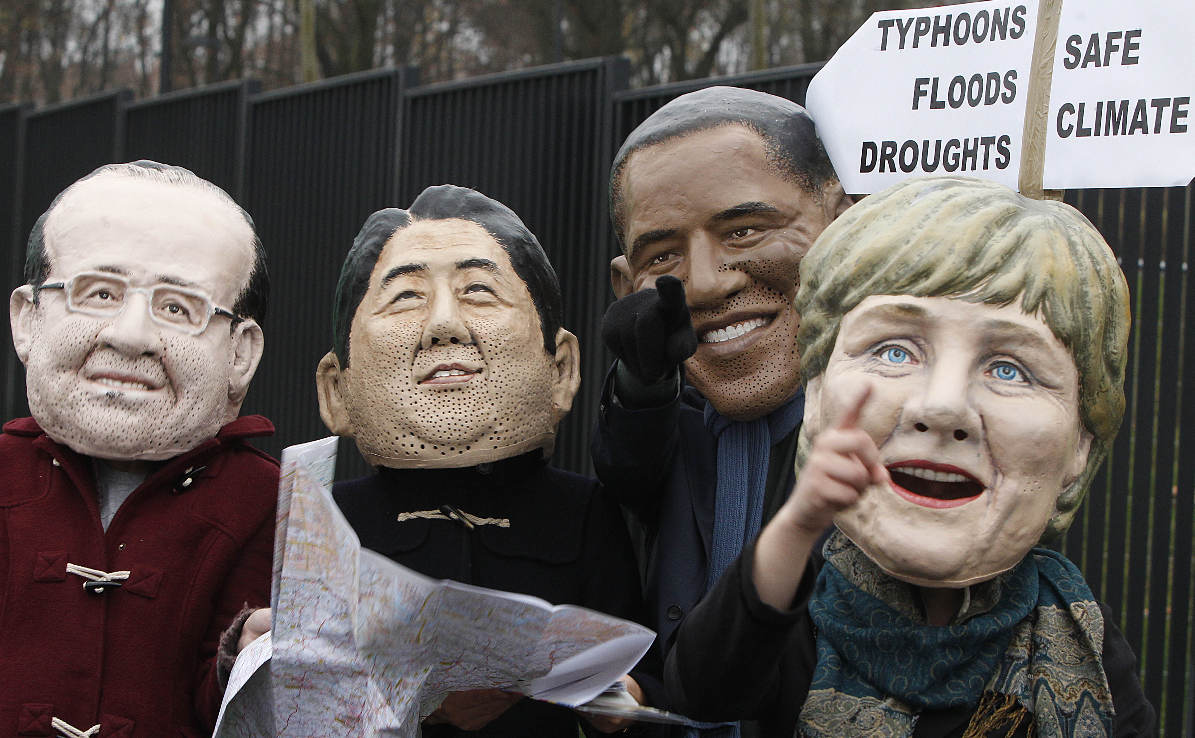 Climate activists donning the masks of leaders point in the direction they want