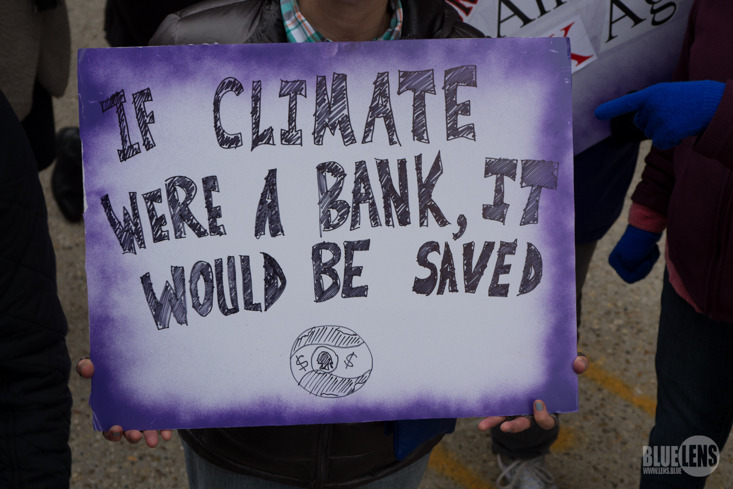 "If the climate were a bank, it would be saved," protest sign from the Women's March. Image: Wikimedia Commons/Mark Dixon