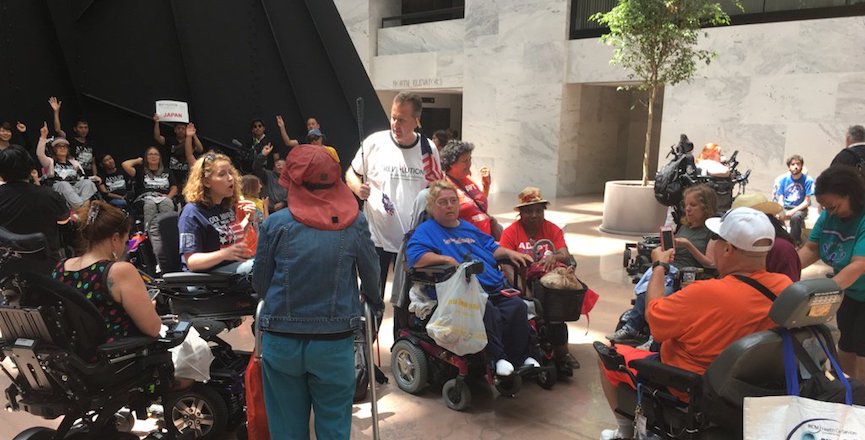 Stephanie Woodward and other activists gather in the atrium of the Hart Senate Office Building, prior to their arrests. Image: Twitter/NationalADAPT