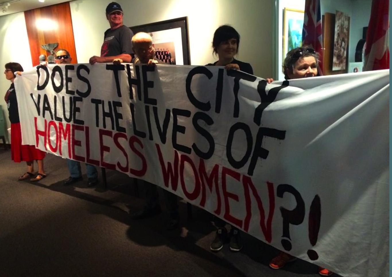 Advocates on homelessness hold a banner outside the mayor's office in Toronto.