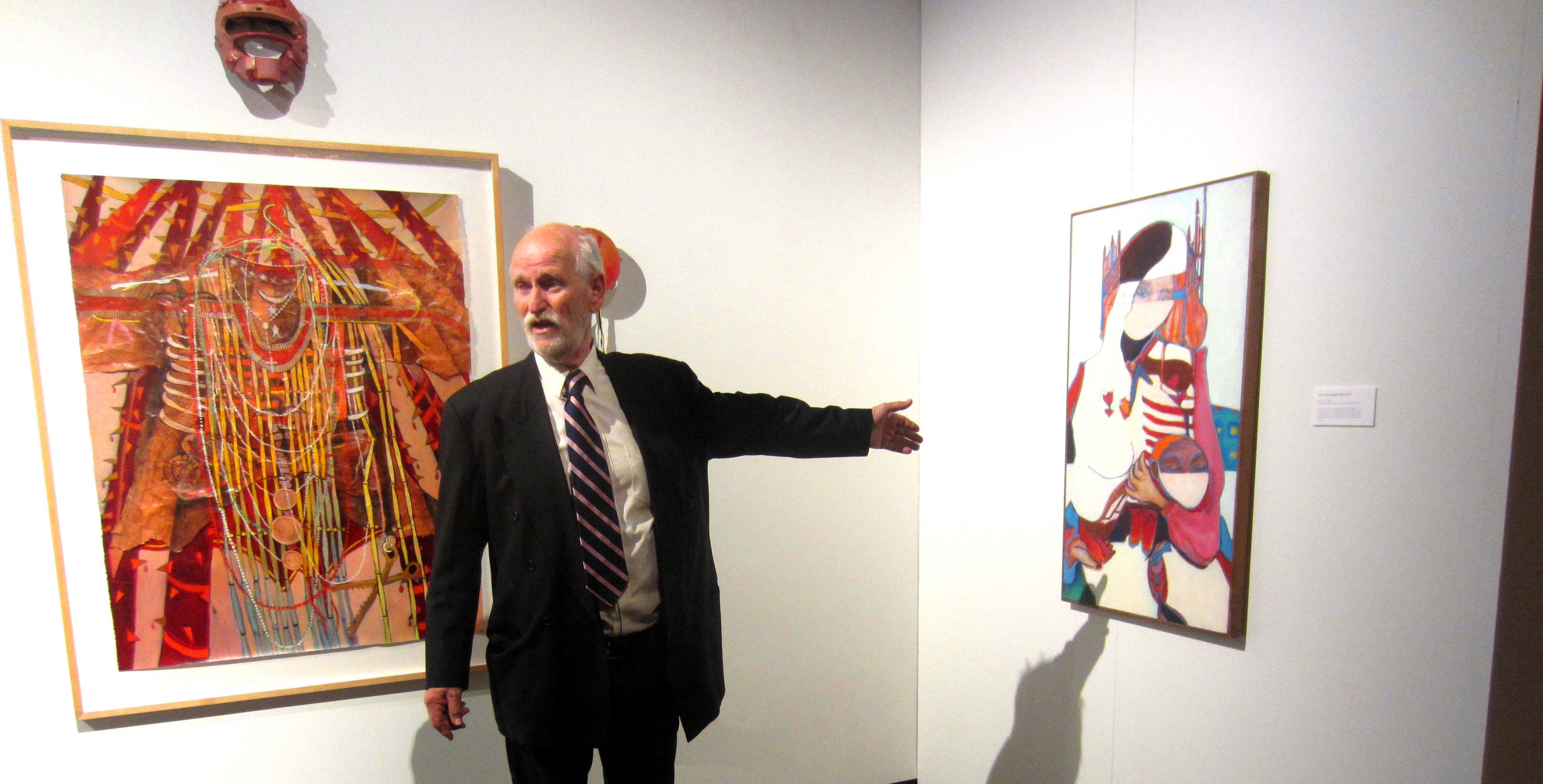 Mike Schubert points to one of Joane Cardinal-Schubert's paintings.