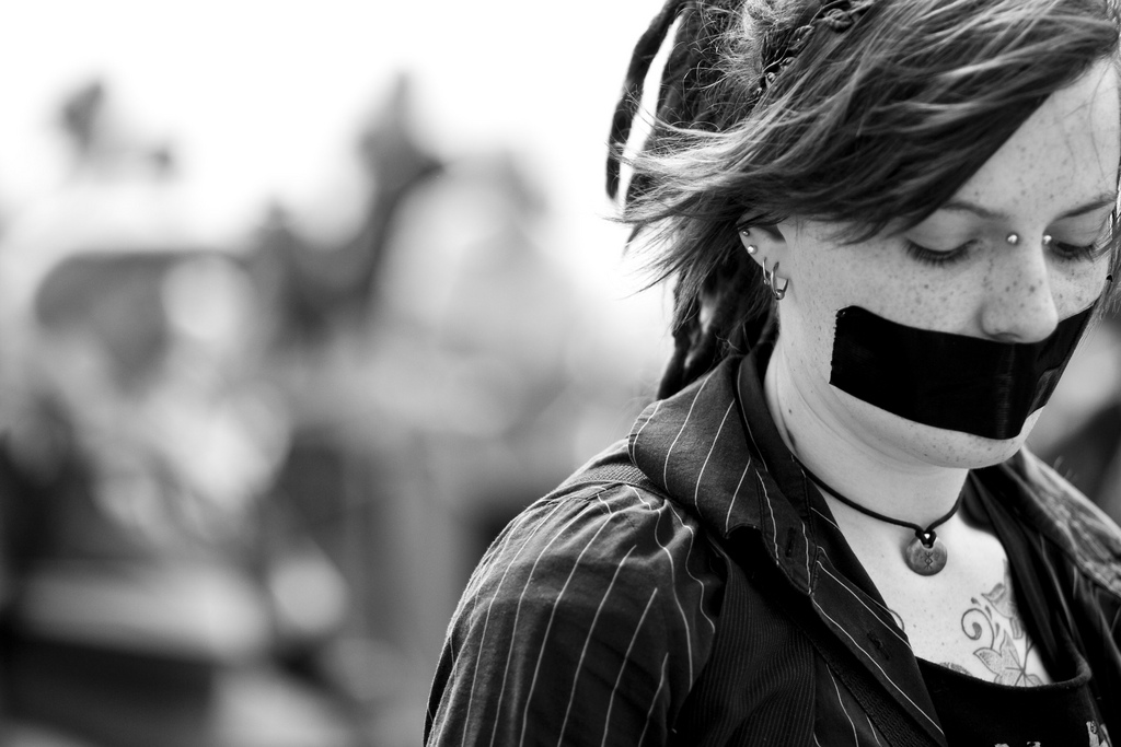 Woman with tape over mouth. Photo: Paola Kizette Cimenti/flickr