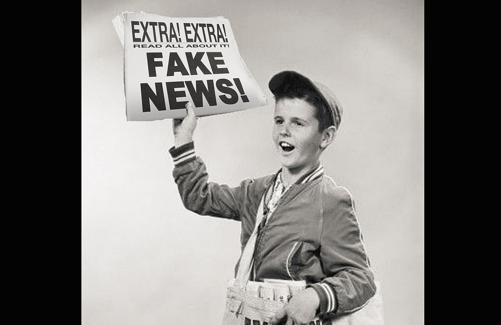 Paperboy holds a newspaper with fake news. Photo: The People Speak!/Flickr