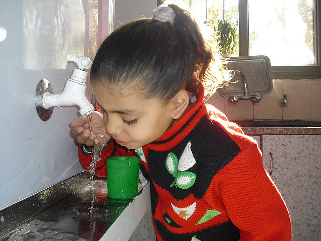 A kindergartener in Maghazi Refugee Camp, Gaza, drinks clean water from a Maia Project unit installed in Dec. 2009. Photo: Mohammed Majdalawi/Middle East Children's Alliance