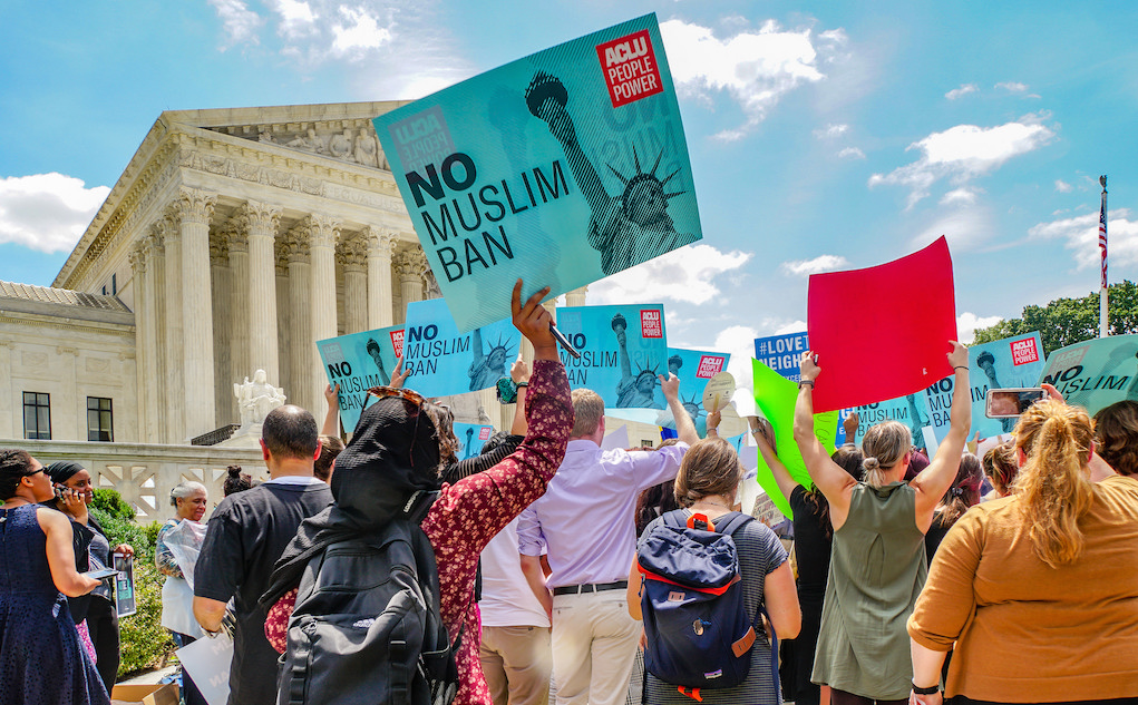 People hold signs protesting Muslim ban. Photo: Ted Eytan/Flickr