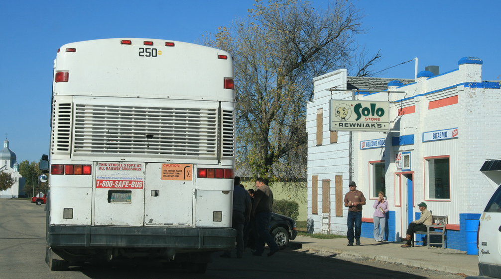 Bus stopped by storefront in Manitoba. Photo: seniwati/Flickr