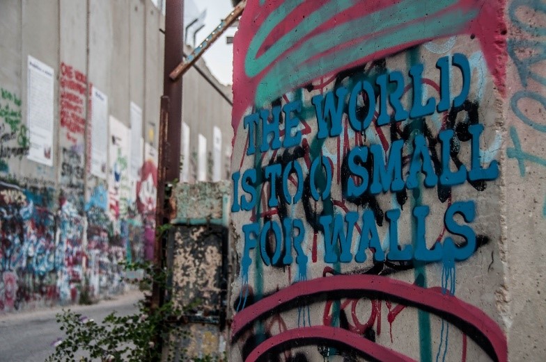 “The World Is Too Small For Walls.” Graffiti on a concrete block in front of the apartheid wall in Bethlehem.  Photo: Laurence Chiasson