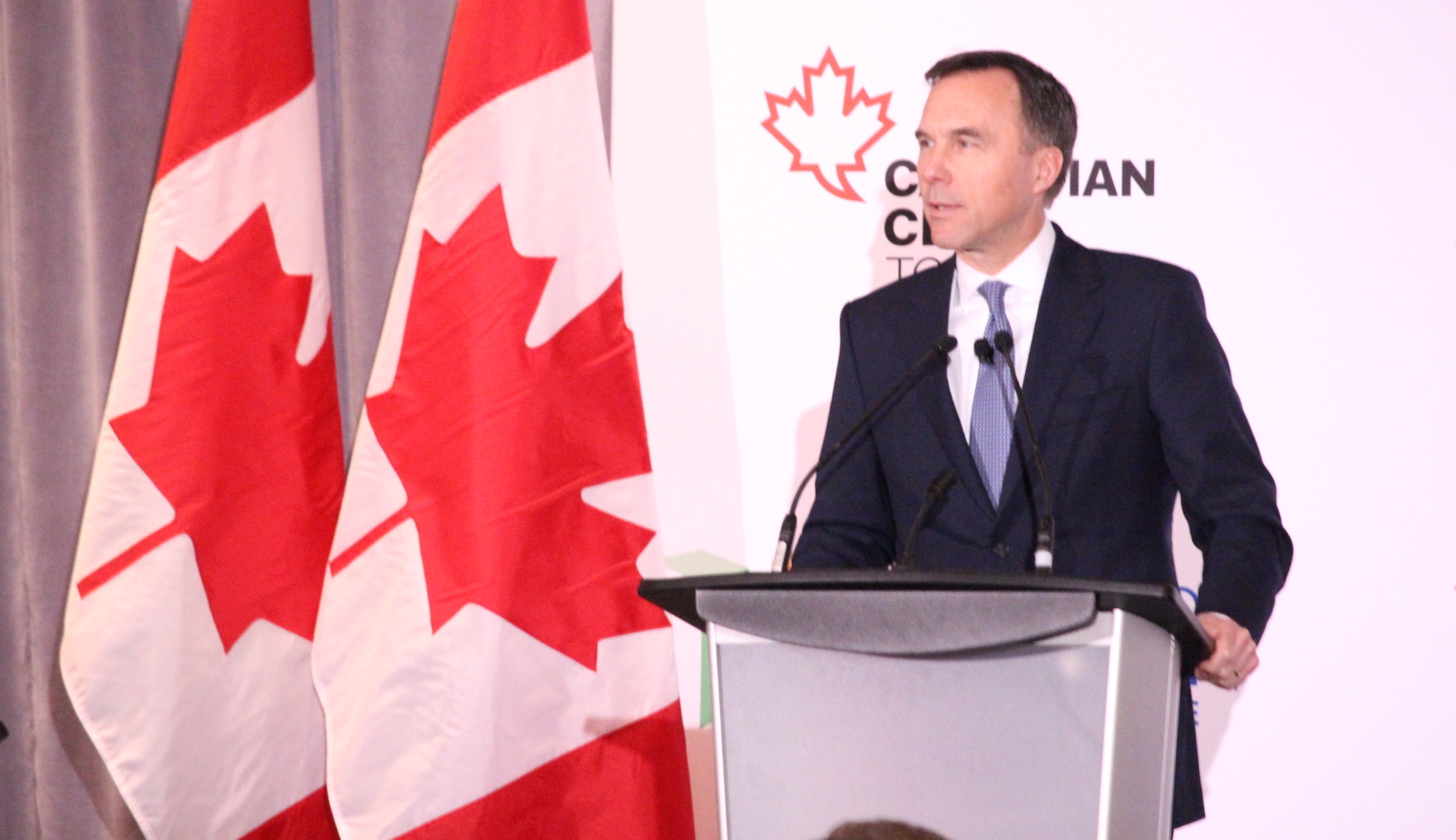 Bill Morneau speaks at podium. Photo credit: Rosemary Frei