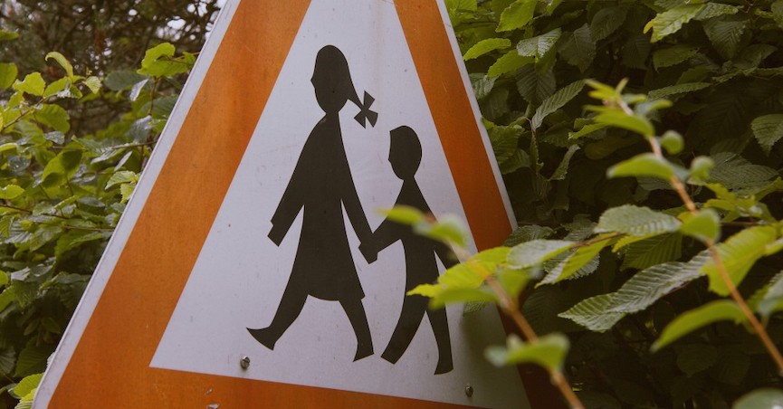 Street sign with mother and child crossing the street. Image: barnimages.com/Flickr