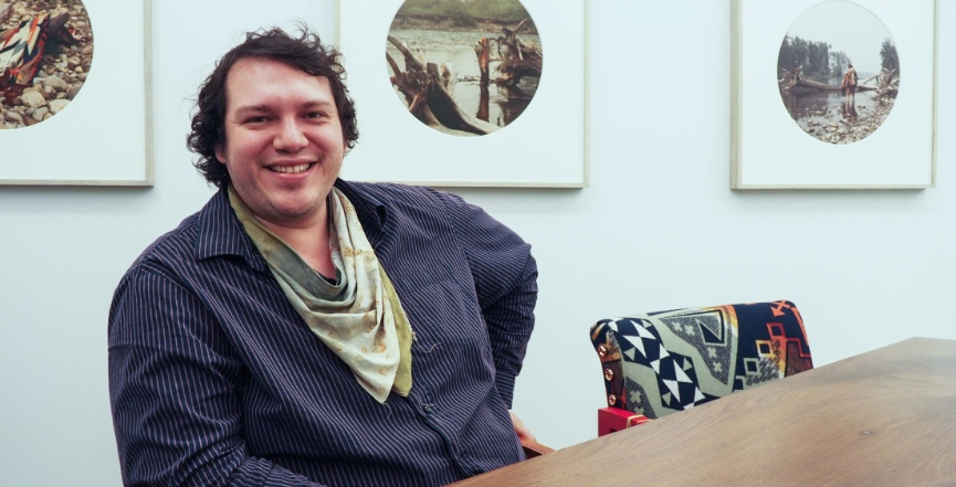 Jared Tailfeathers sits at a table in the Elders' Guidance Circle at the Calgary Public Library. The piece is one of several furnishings called "Tina Dik’iizh | clear road or clear trail," created by Glenna Cardinal, a Saddle Lake Cree Nation member. Image: Olivia Robinson/rabble