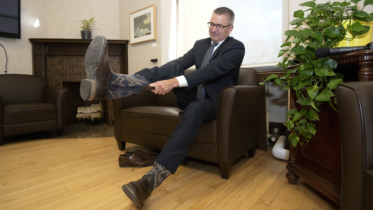 Alberta Minister of Finance Travis Toews puts on his cowboy boots in preparation for the release of the budget. Image: Government of Alberta/Flickr