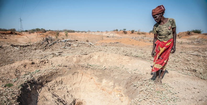 Adelaide Maphangane stands beside an empty water hole in the district of Mabalane, Mozambique. Image: International Federation of Red Cross and Red Crescent Societies/Flickr