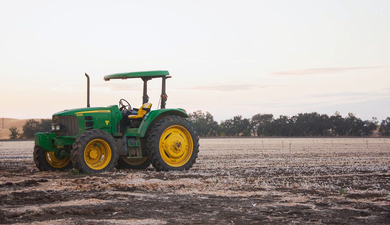 Farm tractor sitting in a field. Image credit: Nathan Lugo/Unsplash