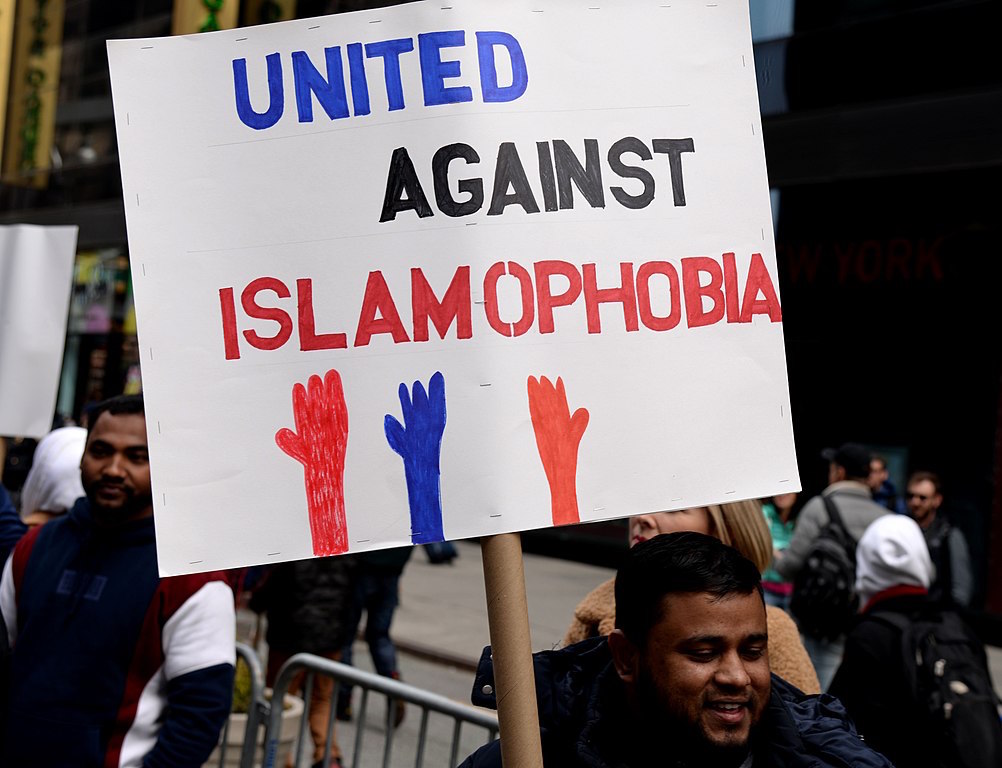 Man holds sign reading "United Against Islamophobia." Image credit: Felton Davis/Wikimedia Commons