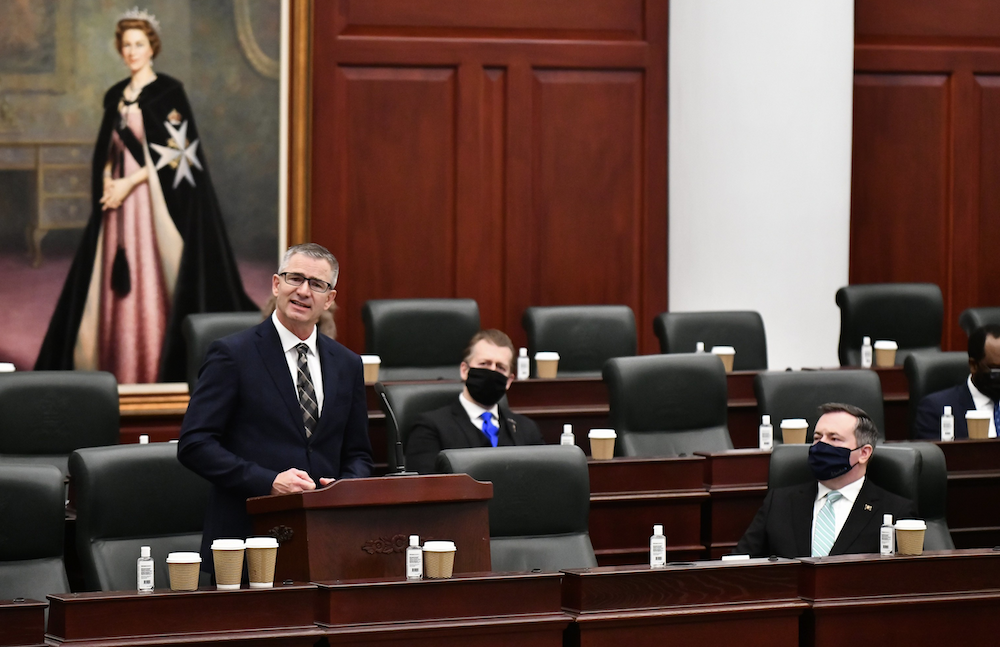 Alberta Finance Minister Travis Toews reads his budget speech in a COVID-19-safe Legislature as Premier Jason Kenney looks on. Image credit: Alberta Newsroom/Flickr - Photograph by EPIC Photography/Legislative Assembly Office