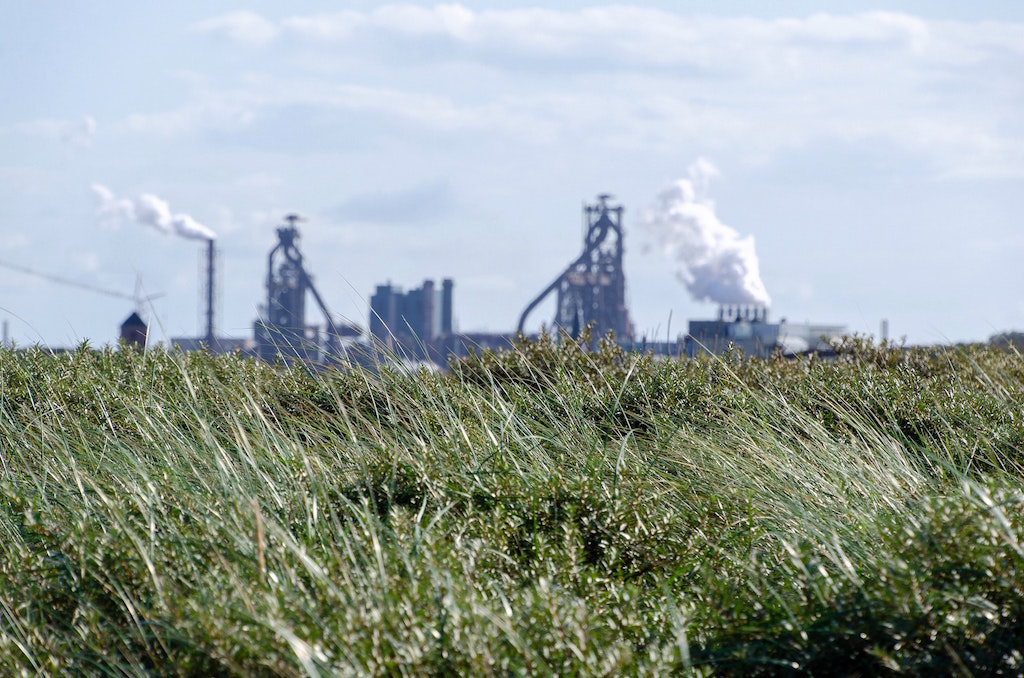 Industrial factory in grassy field. Image credit: Anton Eprev/Unsplash