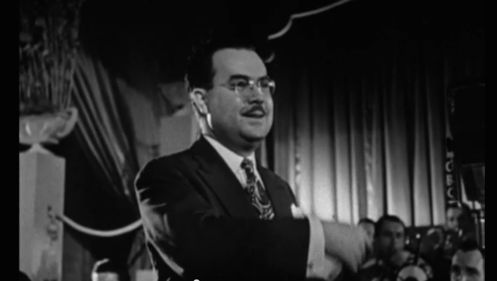 Mart Kenney conducting during a musical performance. Image: Still from "Canada Calling" documentary/NFB