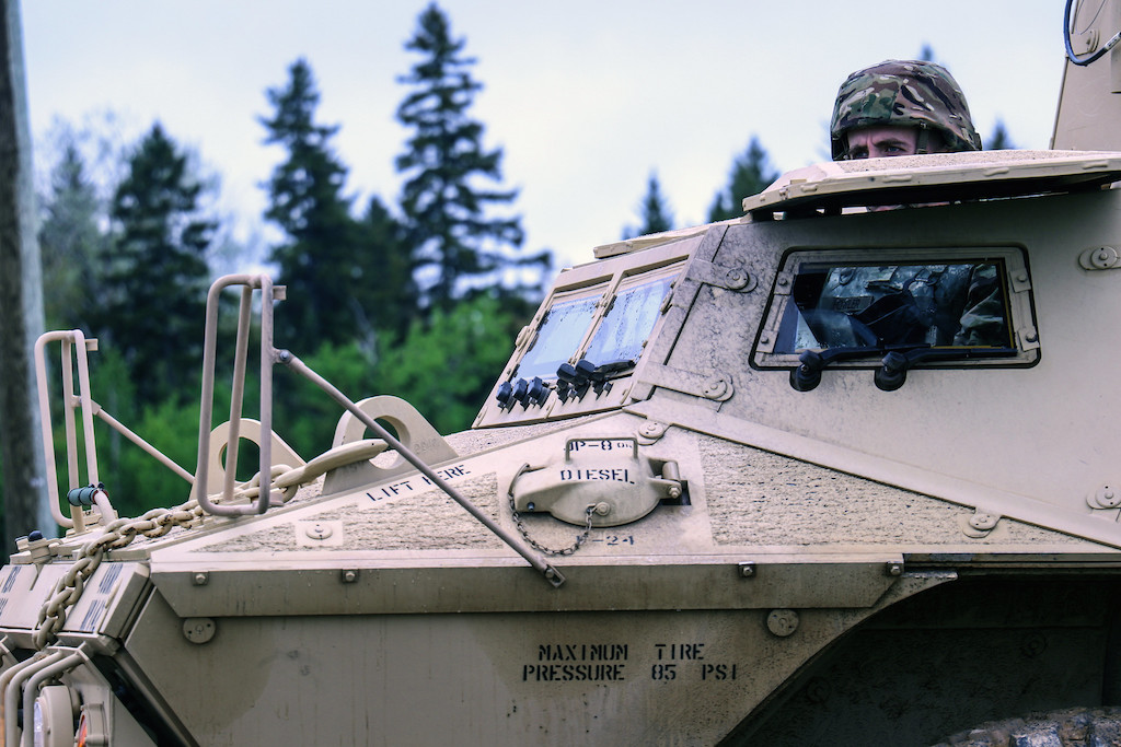 A  U.S. soldier from the Maine National Guard looks out of his armoured vehicle as part of military exercises in Gagetown, New Brunswick. Image credit: The National Guard/Flickr