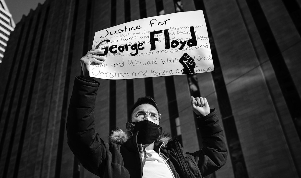 A protester holds a "Justice for George Floyd" sign outside the Hennepin County Courthouse in Minneapolis, as the trial of former police officer Derek Chauvin began. Image credit: Lorie Shaull/Flickr