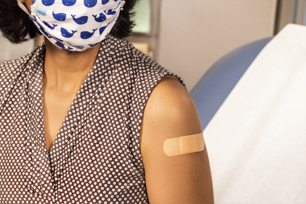 Person wearing mask with bandage on arm. Image credit: CDC/Unsplash