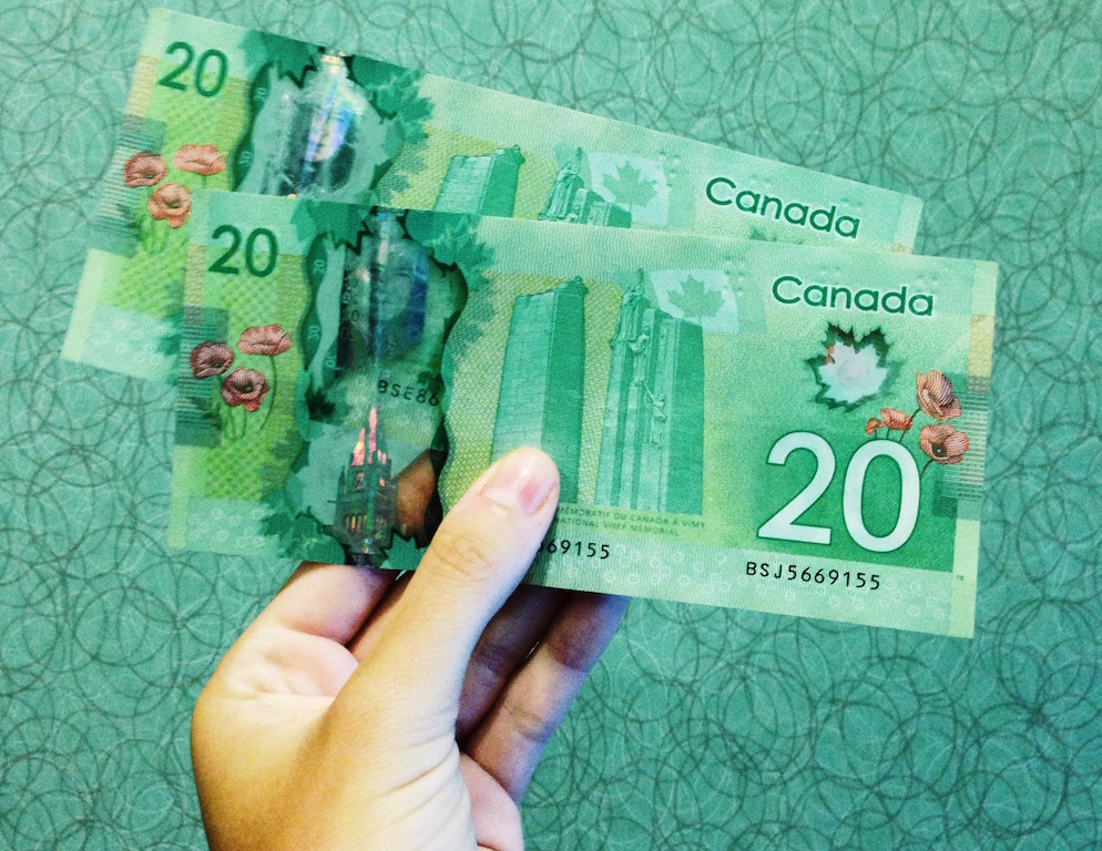 Hand holding two Canadian twenty dollar bills. Image credit: Michelle Spollen/Unsplash