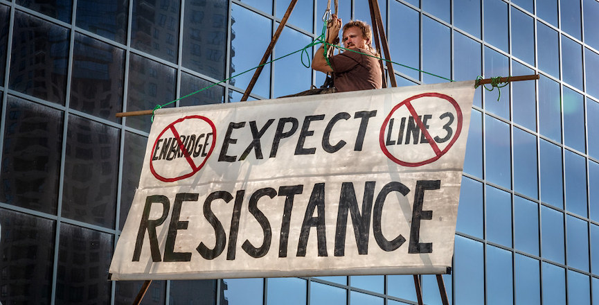 A protester outside the MN Public Utilities Commission protesting Enbridge's Line 3 in downtown St Paul, MN. Image credit: Lorie Shaull/Flickr.