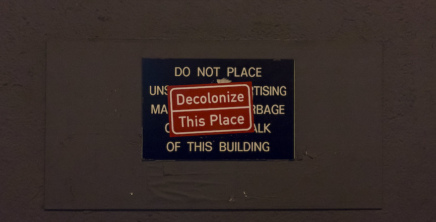 A sign that reads: "decolonize this place." Image: Billie Grace Ward/Flickr