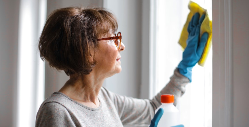 A woman cleans a window. Image credit: Andrea Piacquadio/Pexels