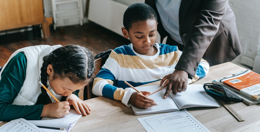 Two students study at a desk. Image credit: Katerina Holmes/Pexels.