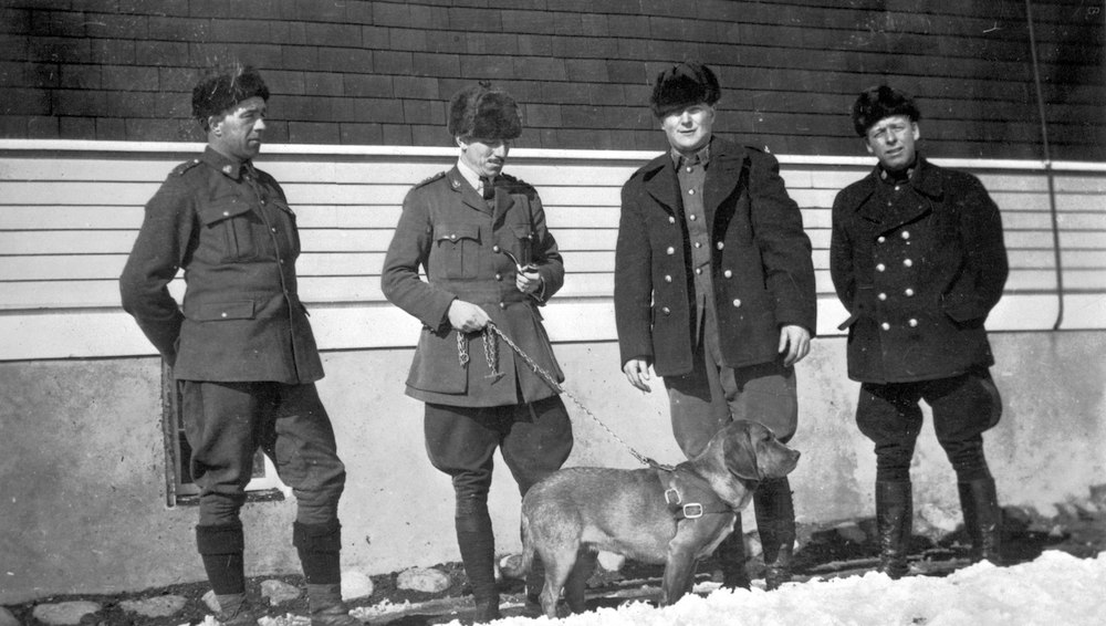 A black and white photo from the last time Alberta had a provincial police force, featuring four uniformed officers and a dog. Image: Provincial Archives of Alberta