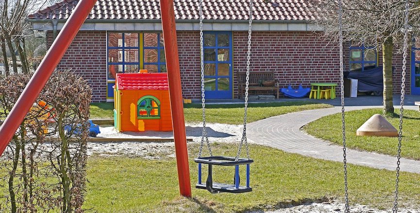 A children's playground featuring an empty swing set. Image: Erich Westendarp/Pixabay.