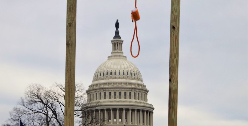 The U.S. Capitol building framed by a makeshift gallows on January 6, 2021 during the siege by Donald Trump supporters. Image: Tyler Merbler/Wikimedia Commons