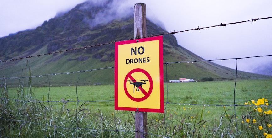 A sign reading "no drones" on a fencepost. Image: Martin Sanchez/Unsplash