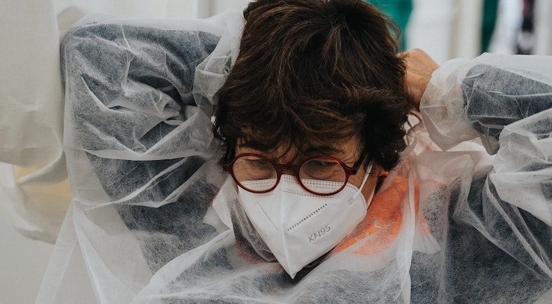 A health-care worker at a COVID-19 testing site replaces her gown and mask. Image: Mat Napo/Unsplash