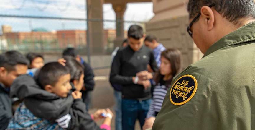 A U.S. Border Patrol agent apprehends migrants who surrendered to him after crossing the Rio Grand River in El Paso Texas on March 18, 2019. Image: U.S. Customs and Border Protection/Mani Albrecht/Picryl